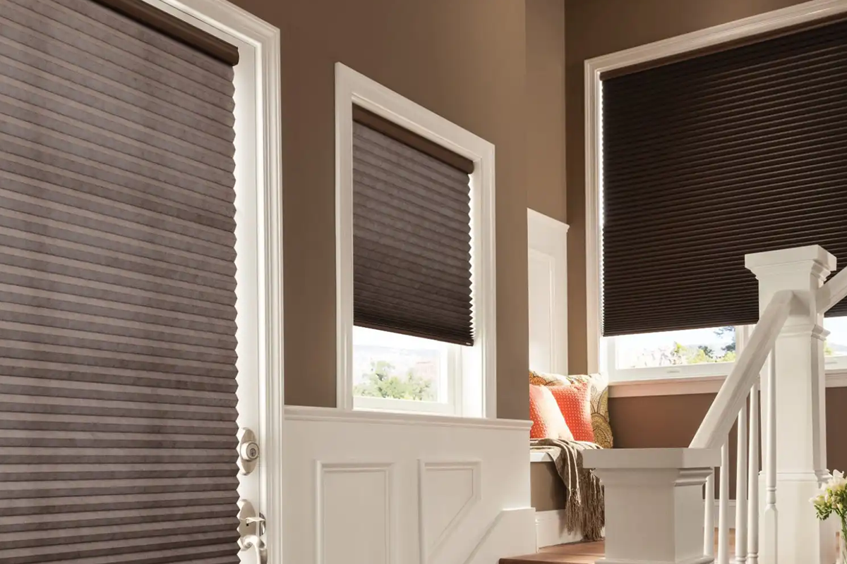 A living room with a stair case and window shades